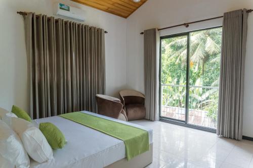 a bedroom with a bed and a large window at Ditara in Katugastota