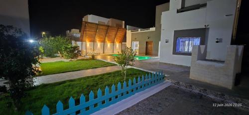 a house with a swimming pool at night at Dar fadloun in Midoun