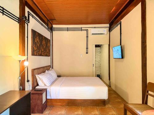 a small bedroom with a bed and a desk at Nalendro Villa Borobudur in Borobudur