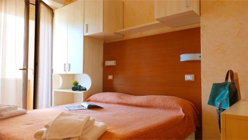 a bedroom with a bed with a wooden head board at Hotel Condor in Milano Marittima