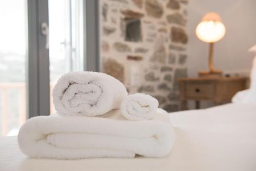 dos toallas sentadas encima de una cama en Athina Exquisite Houses, en Kástron