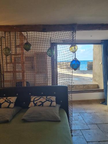 a bedroom with a bed with a view of the ocean at Maison de pêcheur les pieds dans l'eau in Ersa