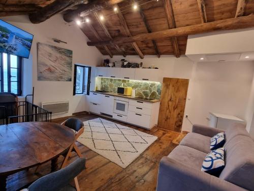 a living room with a couch and a table at Maison de pêcheur les pieds dans l'eau in Ersa