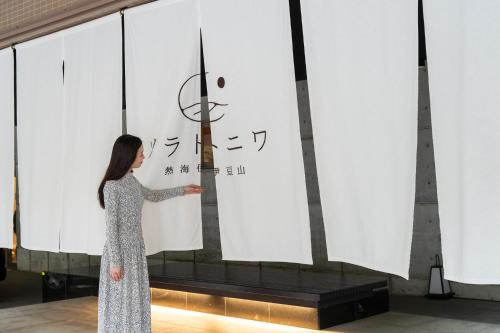 a woman standing in front of a screen with a flag at Soratoniwa Atami Izusan in Atami