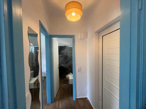 a hallway with a blue door and a light at Kosinmyheart Apartment 11 & Studio10 in Kos