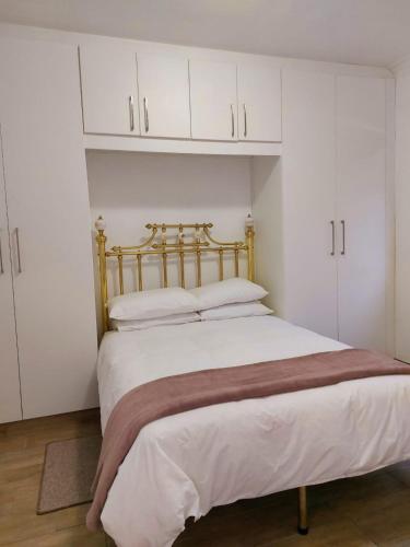 ein Schlafzimmer mit einem großen Bett und weißen Schränken in der Unterkunft Die Regte Plek in Despatch