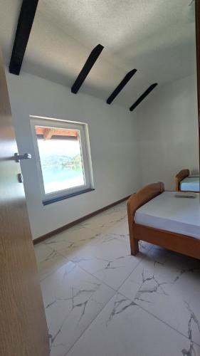 a bedroom with a bed and a window at Captains Seherzada Apartment in Železnička Stanica Ostrožac
