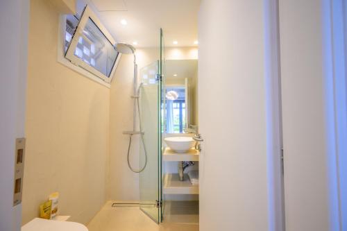 a bathroom with a glass shower and a sink at Horizon House - Beachfront Escape in Nerántza