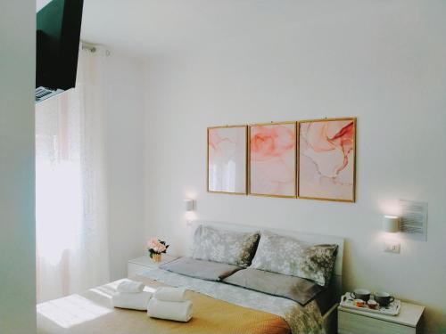 a small bedroom with a bed and a picture on the wall at Le Camelie camera in Bosa