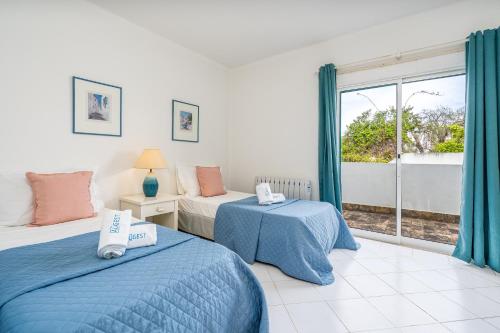 a bedroom with two beds and a window at Prainha Lounge in Alvor