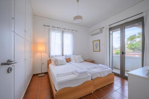 a bedroom with a bed and a large window at Horizon House - Beachfront Escape in Nerántza