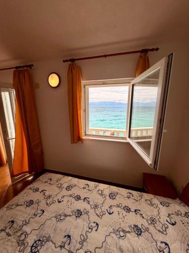 a bedroom with a bed and a window with the ocean at Villa Ocean Breeze First Row in Brist