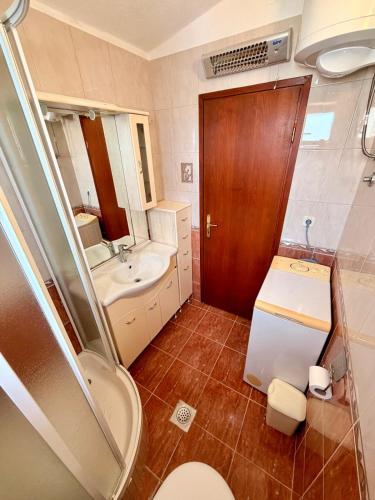 a small bathroom with a toilet and a sink at Villa Ocean Breeze First Row in Brist