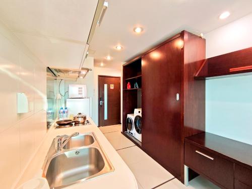 a kitchen with a stainless steel sink in a room at Shanghai Cosmo World Union Service Apartment in Shanghai
