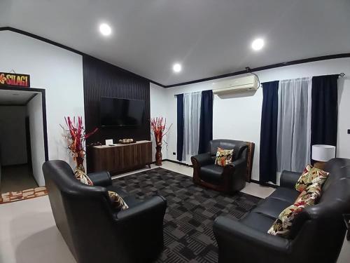 a living room with two chairs and a flat screen tv at Silagi Holiday Home in Nadi