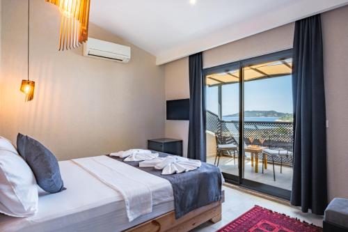 a bedroom with a bed and a balcony at Çınar Butik Hotel in Kaş