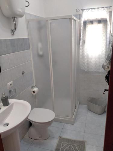 a bathroom with a shower and a toilet and a sink at Le Camelie camera in Bosa