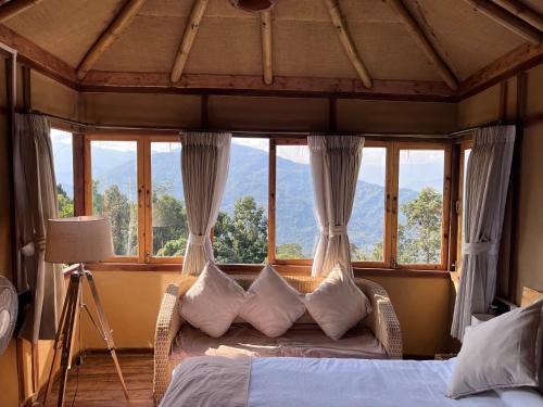 a bedroom with a bed with a large window at Art Mile Kalimpong in Kalimpong