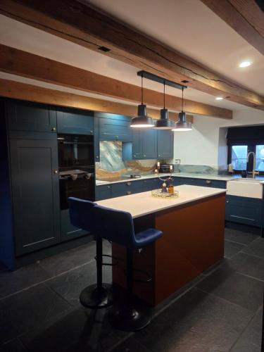 a kitchen with blue cabinets and a island with a chair at The Barn in Crumlin