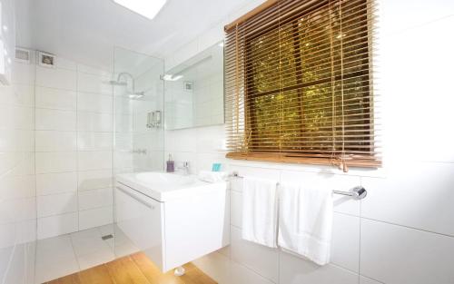 a white bathroom with a sink and a mirror at Seaside Retreat in Mitchells Island