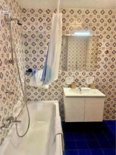 a bathroom with a shower and a tub and a sink at Chalet Costa Rotian in Commezzadura