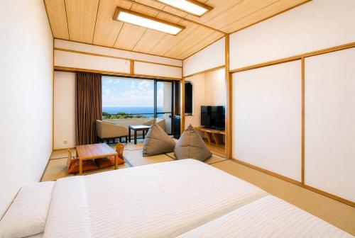 a room with two beds and a living room at Soratoniwa Atami Izusan in Atami