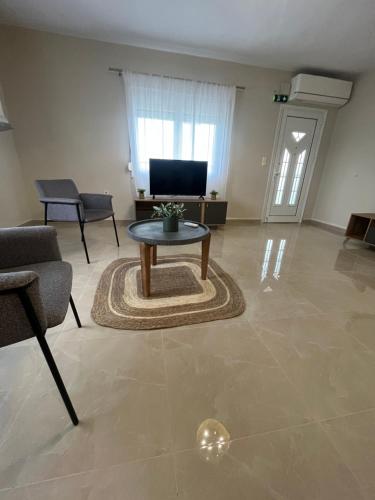 a living room with a coffee table and a tv at Sky Apartment in Ofrínion