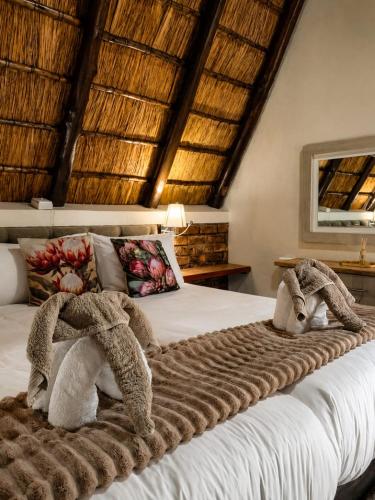 a bedroom with a bed with towels on it at Selukwe Safari Lodge in Marloth Park