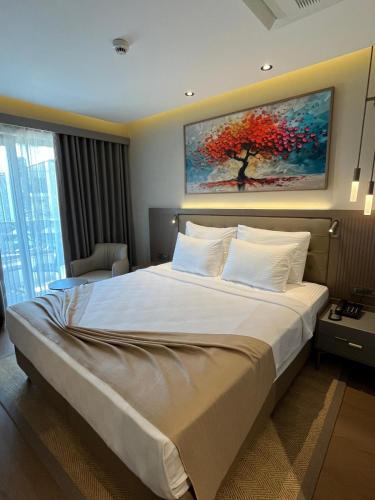 a bedroom with a large bed with a painting on the wall at Göcek Lykia Resort Premium Concept Hotel in Göcek