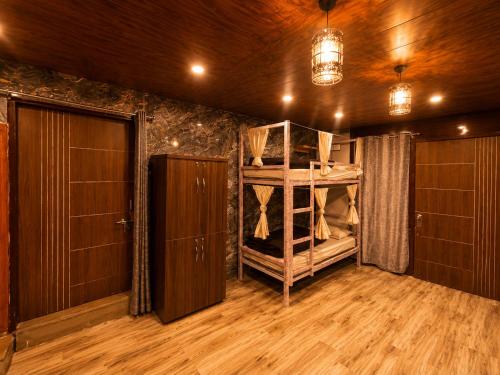 a room with a bunk bed and a door at Peakaboo Manali in Manāli