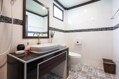a bathroom with a sink and a toilet at Bang Po Hut in Ban Bang Po
