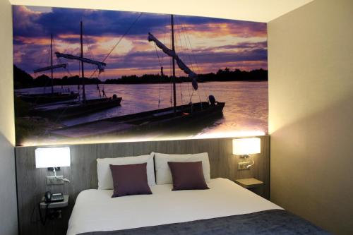 a bedroom with a bed and a painting of a boat at The Originals City, Hôtel La Terrasse, Tours Nord in Tours