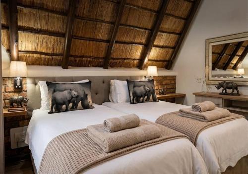 a bedroom with two beds with towels on them at Selukwe Safari Lodge in Marloth Park
