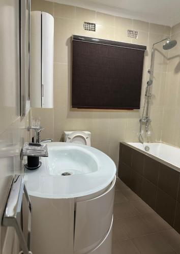a bathroom with a sink and a toilet and a tub at JAYNIEL Apartments in Lusaka