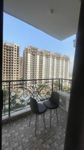 a balcony with two chairs and a view of buildings at Tehzeeb living in Lucknow