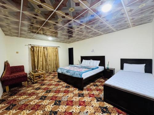 a room with two beds and a chair in it at Valley View Homestay in Bīrgal