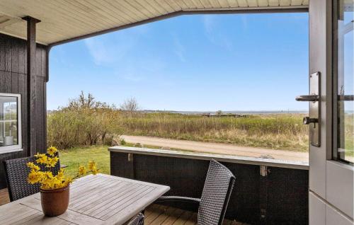 a porch with a table and chairs and a view of a field at 3 Bedroom Cozy Home In Haderslev in Haderslev