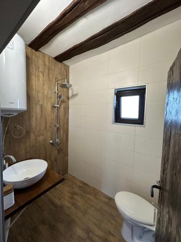 a bathroom with a sink and a toilet and a window at Bachvarov house Бъчваровата къща in Palitsi