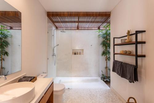 a bathroom with a shower and a toilet and a sink at Villa Pura Bali in Canggu