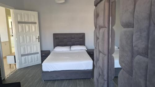 a bedroom with a bed in a room with a door at Sidi Kankouch Bay in Tangier