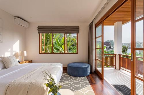 a bedroom with a bed and a balcony at Villa Pura Bali in Canggu