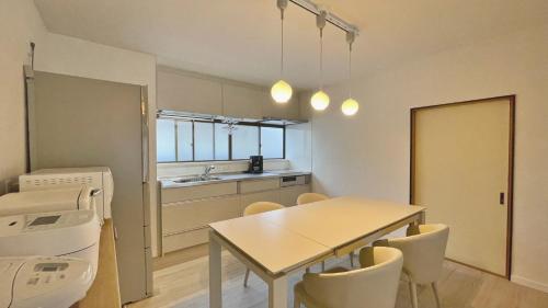 a kitchen and dining room with a table and chairs at Tabinoteitaku 和-WA- in Sendai
