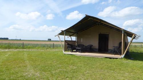a small tent with chairs in a field at Camping Amable in Someren-Heide