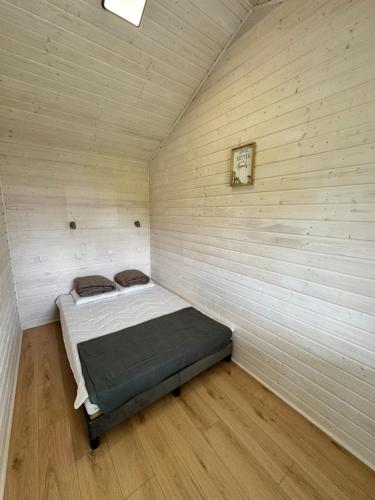 a bedroom with a bed in a wooden wall at Domki GAMA in Gąski