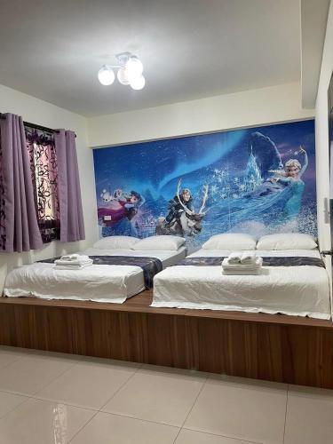 two beds in a room with a mural on the wall at Round toot in Jinning