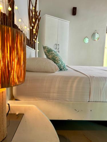 a bedroom with a large bed with a lamp at Papaya Hikkaduwa in Hikkaduwa