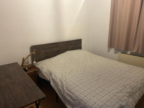 a bedroom with a bed and a wooden table at Le cocon du télésiège - Piscine chauffée - Métabief in Métabief