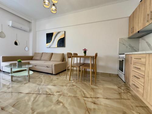 a living room with a couch and a table at Coral Blue By Infinity in Nea Kallikrateia