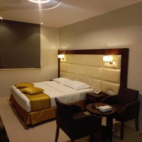 a hotel room with a bed and a table and chairs at شقق نزل التوت للشقق المخدومة in Al Kharj