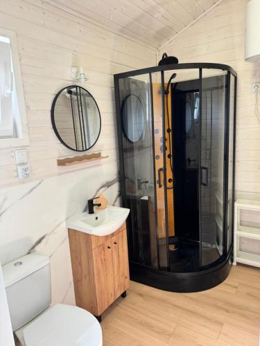 a bathroom with a shower and a sink and a toilet at Domki GAMA in Gąski